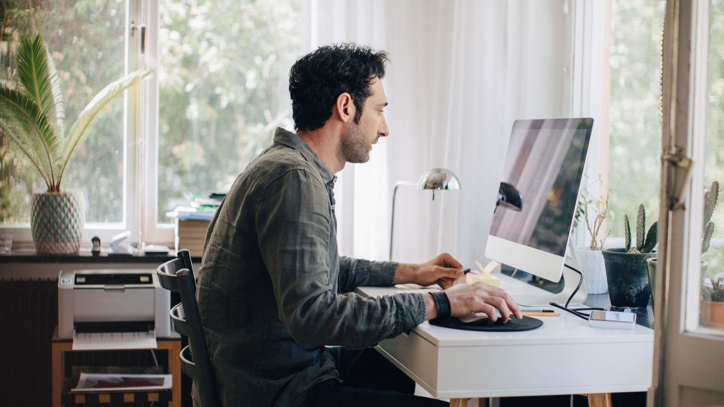 man on computer researching internet speeds