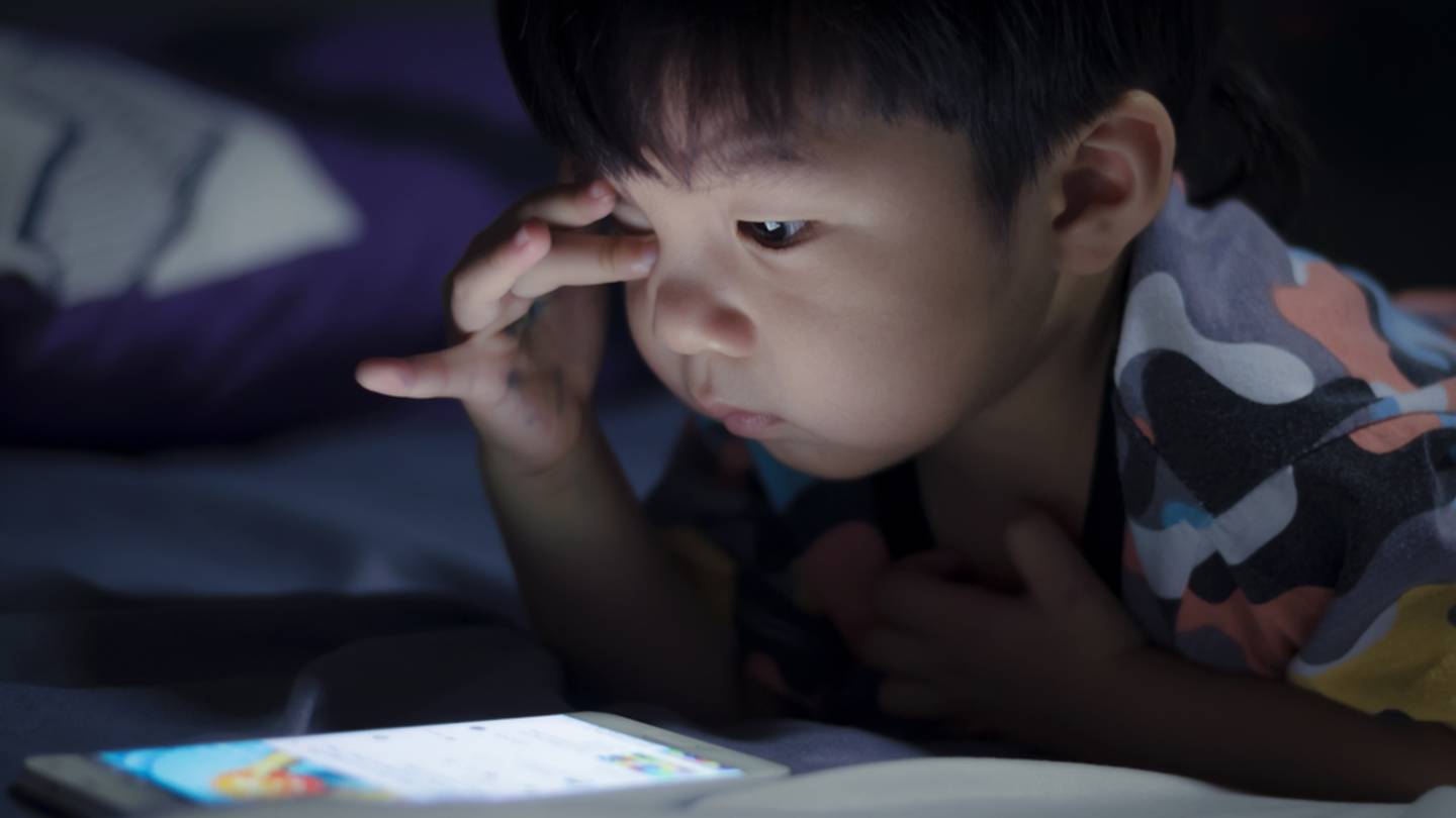 Young boy on his phone at night