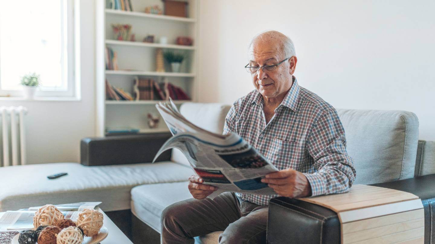 Older man reading newspaper
