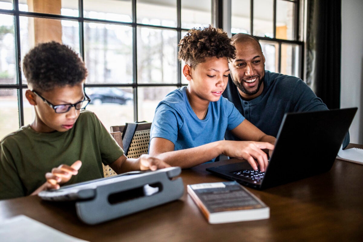 Man with two kids on laptops