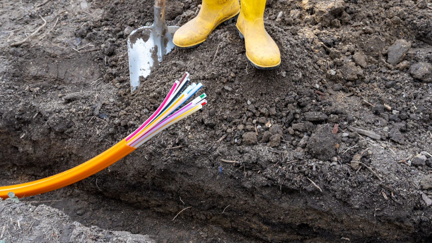 Fiber optic cables being laid in ground