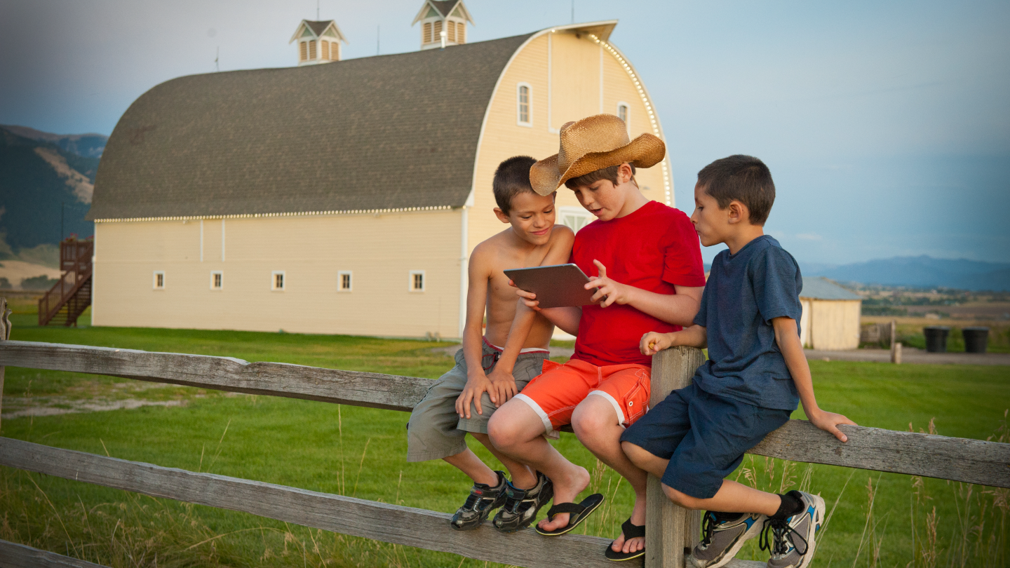 Rural kids on a farm with a tablet.
