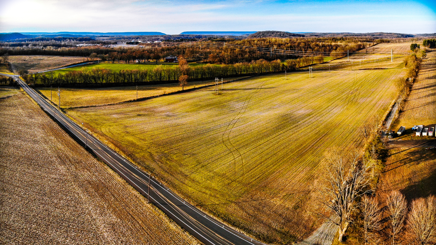 An aerial view of farmlands in Warren County, New Jersey. The Delaware Water Gap can be seen as a distant dip between the hills on the top of the frame.